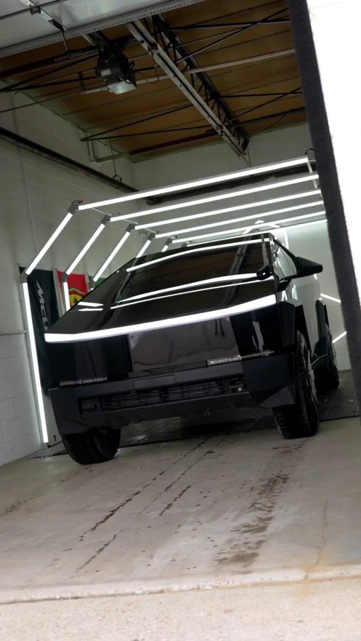 Gloss black Tesla Cybertruck under the hex lights in the Imperial Auto Films install bay