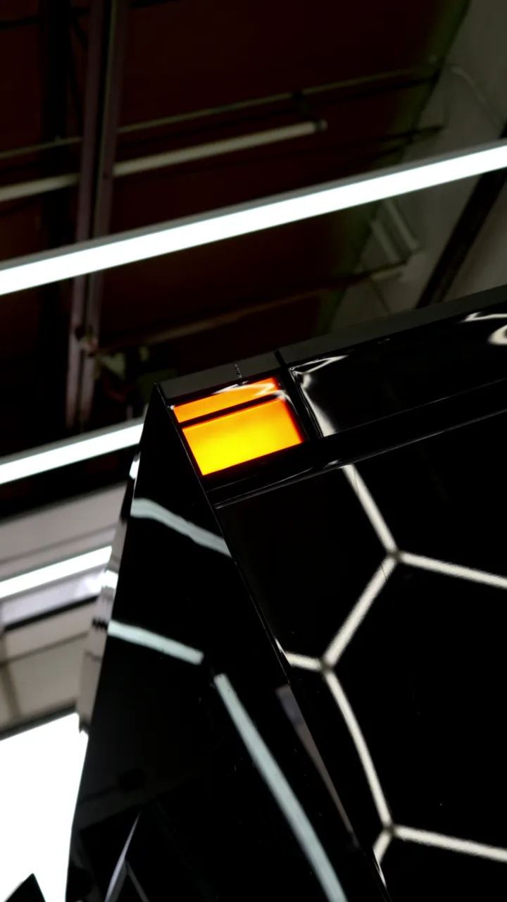 Hex light reflections across the gloss black tailgate of a Cybertruck